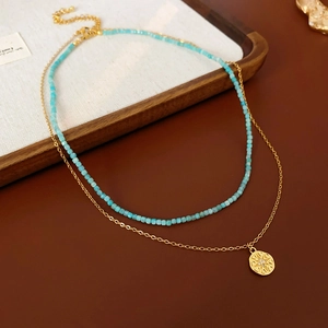 Détail d'un collier à deux rangs avec perles bleues et pendentif étoile doré chic
