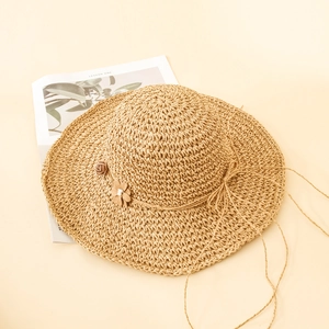 Détail d'un chapeau de paille tissé main avec fleurs 3D et élégant bord large protecteur