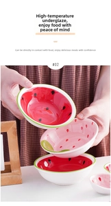 Close-up of hand holding a ceramic bowl with underglaze strawberry and watermelon patterns