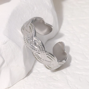 Silver woven texture open ring made of stainless steel on a white stone base