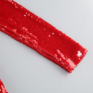 Close-up of vibrant red sequins and textured stitching on the long sleeve dress