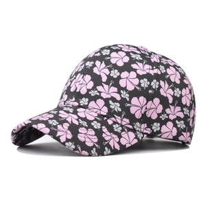 Floral print cotton baseball cap with pink hibiscus pattern on black fabric background
