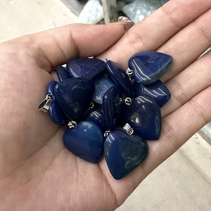 Close-up of heart-shaped polished blue stone pendants with silver metal clasps