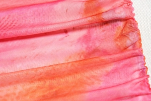 Vue macro de la maille serrée avec un motif tie-dye éclatant en rose et orange