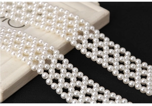 Detailed macro view of elegant white faux pearl woven belt with lustrous grid pattern