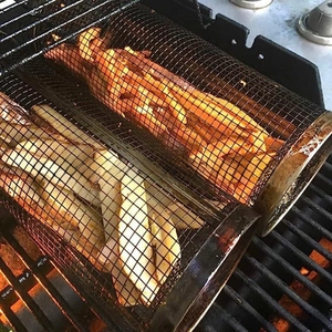 Stainless steel rolling grilling baskets roasting fries and sweet potatoes on BBQ grill