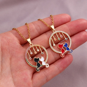 Detail of cat pendants with enamel finishes and zircon accents held by hand