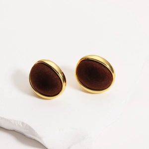Detail of vintage 18K gold plated oval earring with dark brown flocked texture finish