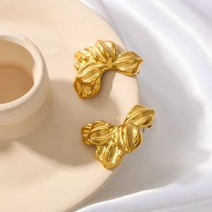 Textured 18k gold plated stainless steel petal earrings on a ceramic dish with silk background