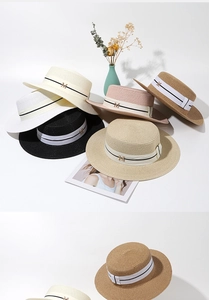 Détail de chapeaux de paille tressés avec rubans élégants et accents dorés en M