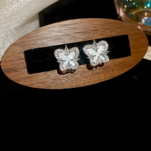 Macro shot of silver butterfly stud earrings with sparkling zircons and mother of pearl