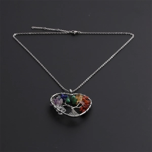 Detail of silver heart tree of life pendant with colorful natural stones and wire wrap