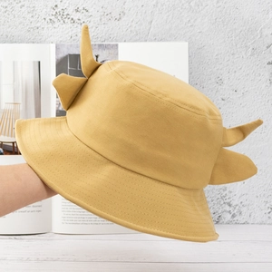 Detail of yellow cotton bucket hat with cute small horns and soft fabric texture