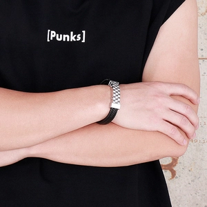 Detailed view of men's braided leather bracelet with wave pattern stainless steel buckle