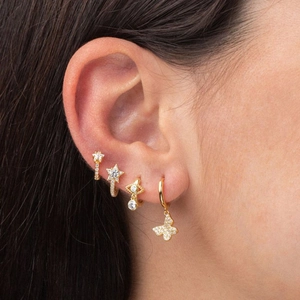 Detail view of gold butterfly, evil eye, and star ear cuff set with clear zircon studs