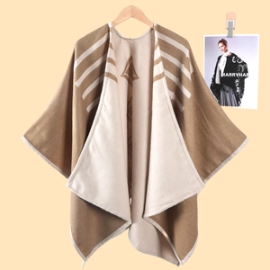 Dettaglio dello scialle in maglia geometrica con motivo a righe e rombi marroni eleganti