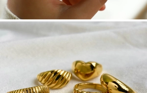 Macro shot of assorted gold stainless steel rings including croissant and heart designs