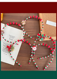 Detail of Christmas beaded headbands with Santa, bells and plaid bows on wooden background