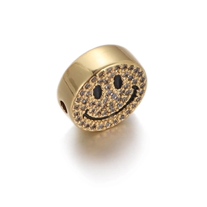Macro detail of a gold-plated smiley face bead with sparkling pave-set cubic zirconia stones