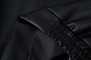 Macro shot of black leather jacket fabric texture with premium stitching details