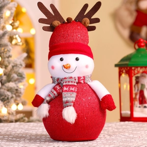 Close-up of a festive knitted snowman with reindeer antlers and a red scarf for Christmas