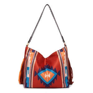 Detail of red bohemian tote bag with geometric ethnic pattern and long brown fringes