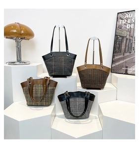 Detailed display of four plaid bucket bags in various colors on elegant display stands