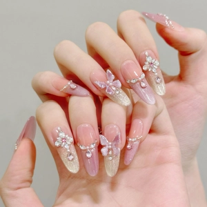 3D butterfly press-on nails with pink glitter gradient and rhinestone accents