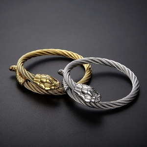 Detailed view of snake head cable bangles in gold and silver steel finish
