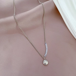 Detail of silver smiley face pendant and engraved smile bar on a sleek steel necklace