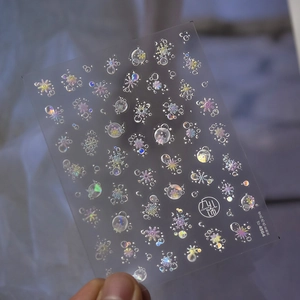 Close-up of laser holographic snowflake nail stickers with iridescent shell luster finish