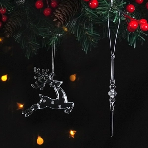 Detailed view of clear reindeer and icicle ornaments hanging on a Christmas tree