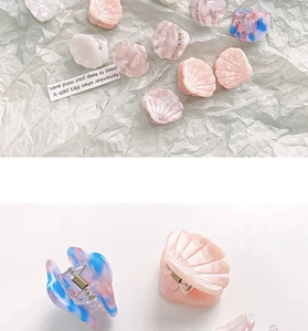 Macro detail of mini acetate shell hair clips in pastel pink, white and blue marble tones