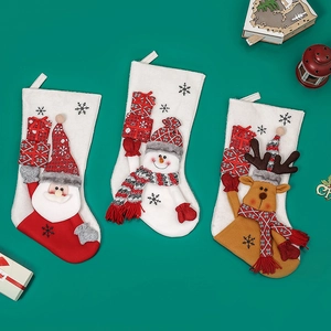 Three plush Christmas stockings with Santa, Snowman, and Reindeer on green background