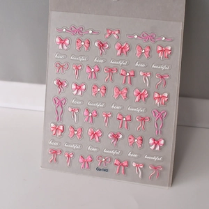 Detail of 3D embossed pink bow nail stickers with sparkling crystal rhinestones and ribbons