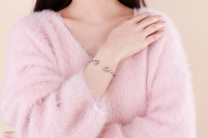 Detail of adjustable silver stainless steel bangle with polished ball ends on wrist