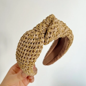 Détail macro du tissage en paille naturelle et nœud central du bandeau bohème
