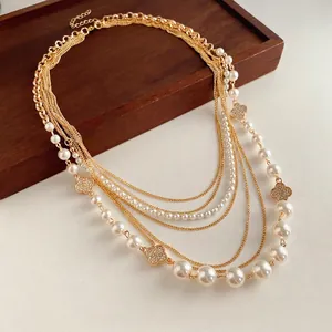 Multi-layer gold chain necklace with white pearls and diamond-studded clover pendants