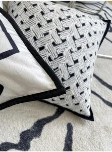 Close-up of velvet woven pillow textures with black piping and geometric patterns