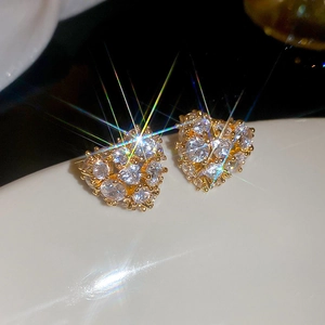 Macro shot of 18k gold plated heart studs with sparkling cubic zirconia starburst effect
