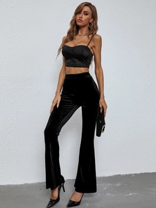 Detail of high-waisted velvet flared trousers and matching crop top in black