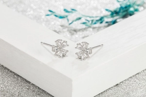 Macro detail of silver five-petal flower earrings with pear-cut cubic zirconia crystals