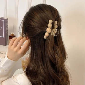 Elegant hair claw with marble texture beads shown on long wavy hair from behind