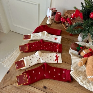 Close-up of festive red and white Christmas socks with bows and gingerbread decor