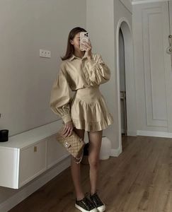 Detailed view of beige button-down shirt with lantern sleeves and ruffled mini skirt set