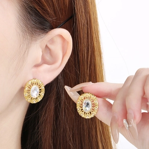 Gold vintage oval earrings with clear gemstone and pearls shown on a female model