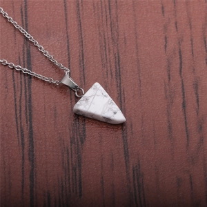 Close-up of a white marble-patterned triangular stone pendant on a silver chain necklace