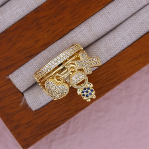 Macro shot of 18K gold plated multi-layer ring with heart, cross, and boy charms