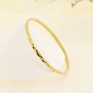 Close-up of gold titanium steel bracelet with textured rhombic pattern and shiny finish