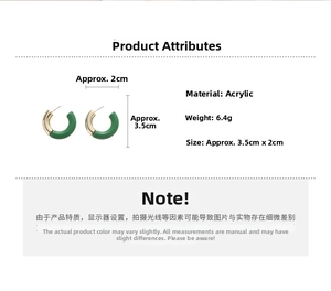 Detail view of C-shaped acrylic earrings in green and gold with 3.5cm x 2cm dimensions